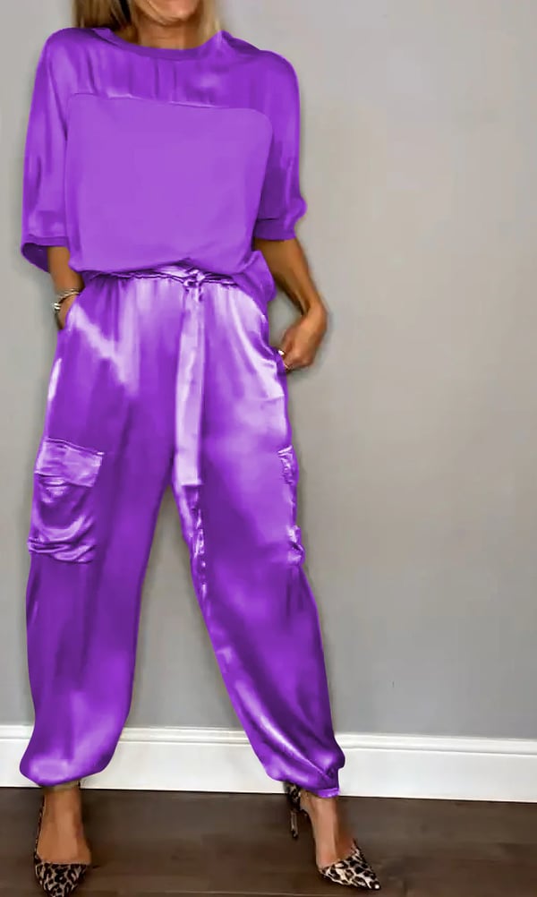 Donna che indossa Clara, completo in raso rosa cipria con top e pantaloni jogger