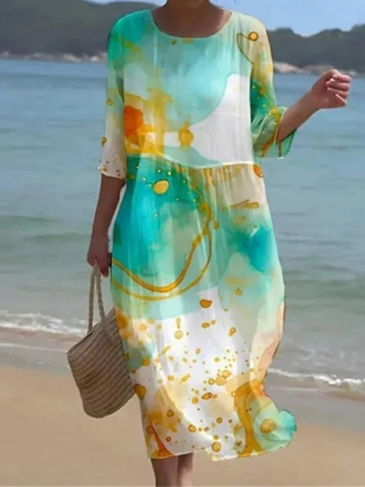 Donna che indossa l’abito floreale elegante Miranda in un ambiente estivo