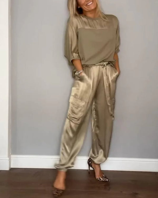Donna che indossa Clara, completo in raso rosa cipria con top e pantaloni jogger
