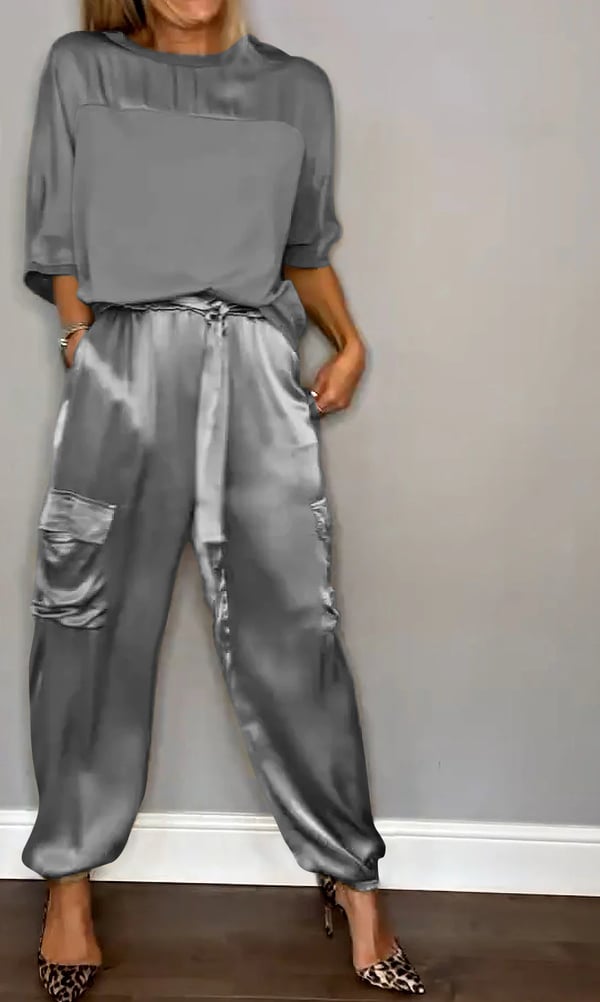 Donna che indossa Clara, completo in raso rosa cipria con top e pantaloni jogger