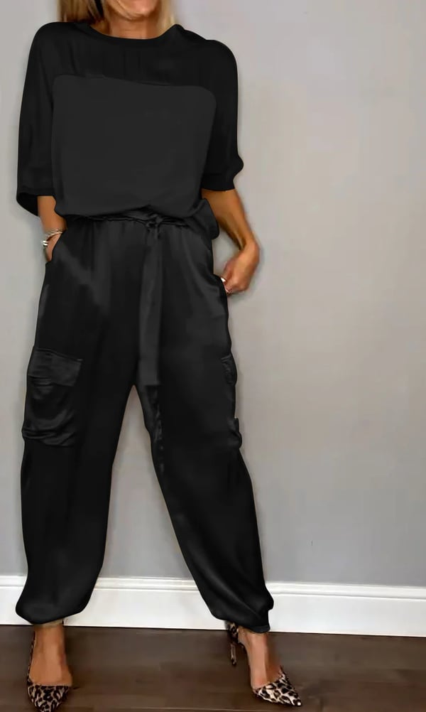 Donna che indossa Clara, completo in raso rosa cipria con top e pantaloni jogger