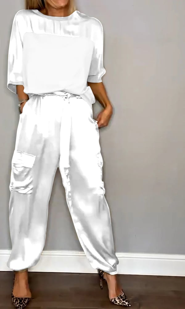 Donna che indossa Clara, completo in raso rosa cipria con top e pantaloni jogger