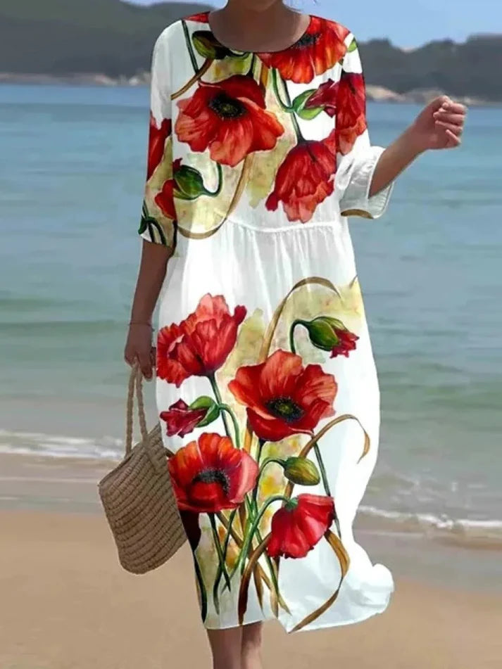 Donna che indossa l’abito floreale elegante Miranda in un ambiente estivo
