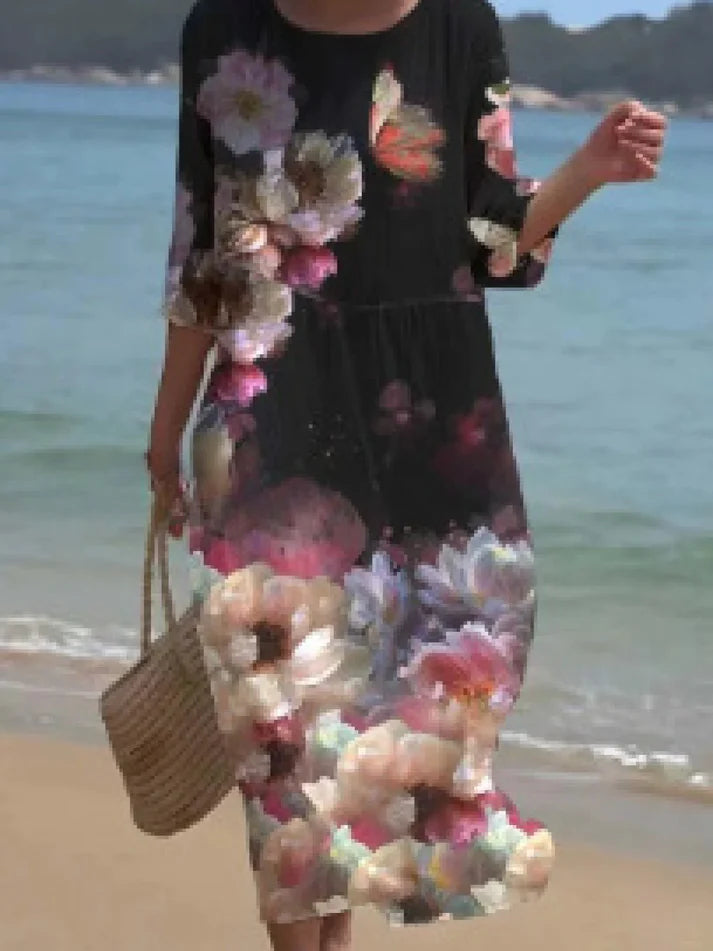 Donna che indossa l’abito floreale elegante Miranda in un ambiente estivo