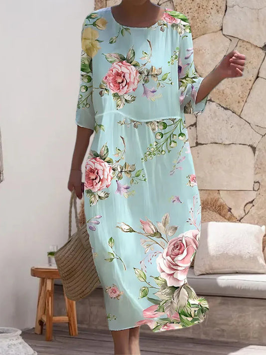 Donna che indossa l’abito floreale elegante Miranda in un ambiente estivo